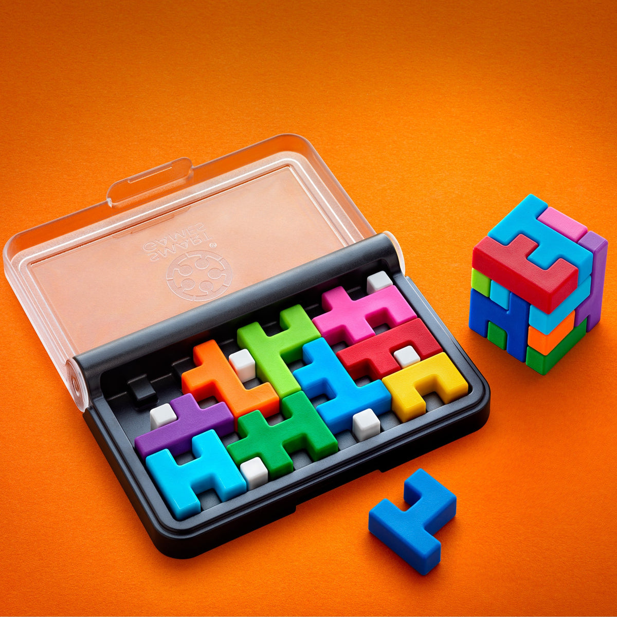 IQ Quub sur fond orange : plateau presque rempli de pièces colorées, à côté d'un cube 3D assemblé avec les pièces