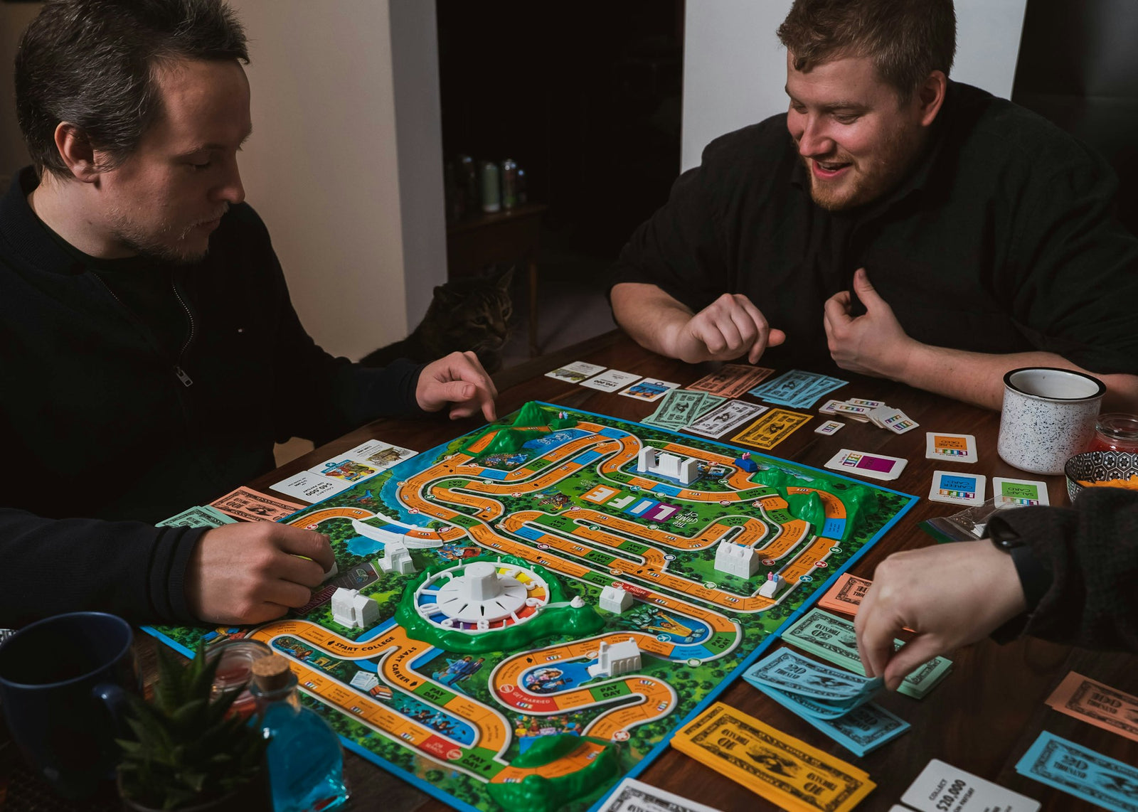 Amis souriants jouant à un jeu de société autour d'une table